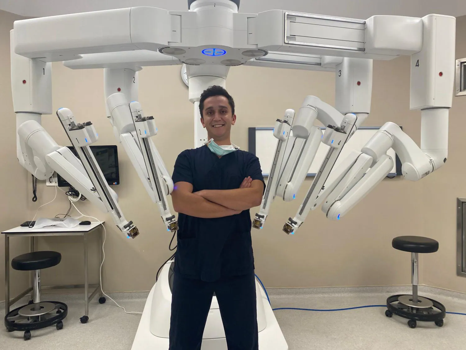 Op. Dr. Kayhan Tarım, dört kollu da Vinci robotik cerrahi sisteminin önünde.
