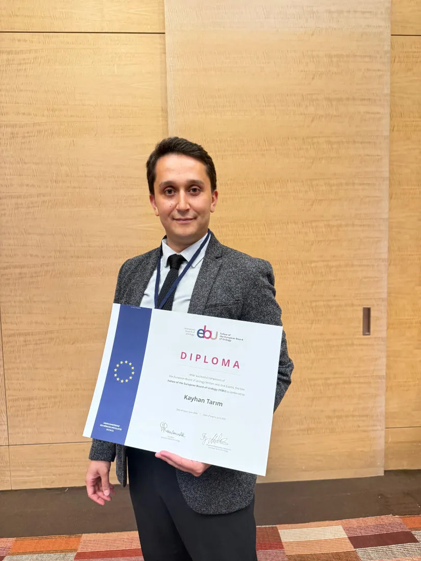 Op. Dr. Kayhan Tarım, European Board of Urology diplomasını elinde tutarken.